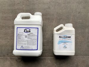 10L jug of flush sitting beside a 3.78L jug of all